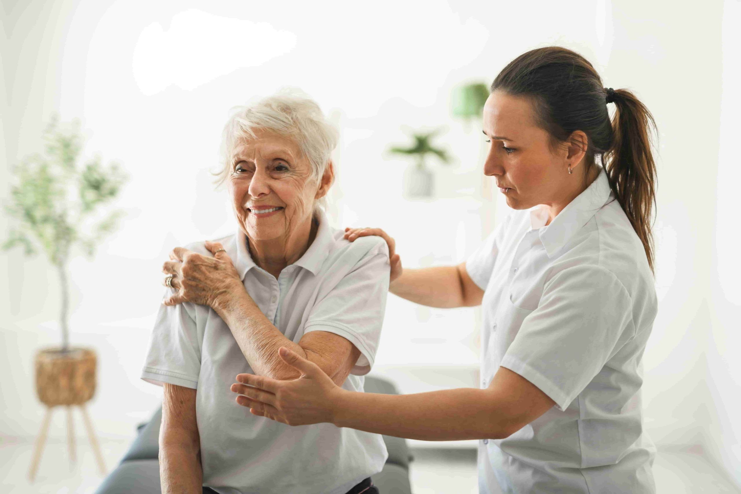 Female physiotherapist treating elderly patient at home in Dubai